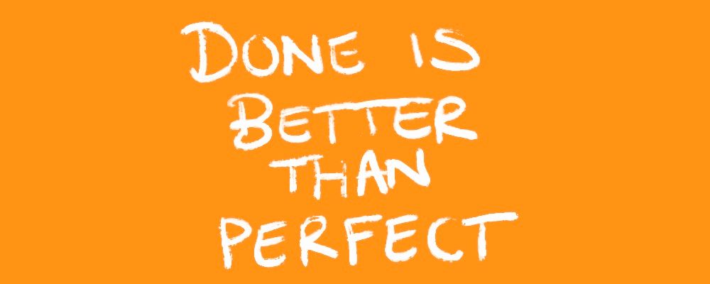Hand-painted white lettering reading Done Is Better Than Perfect on an orange background