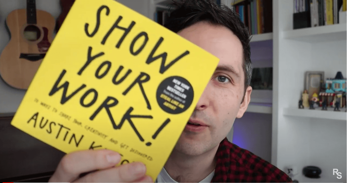 Richard Pryn holding up a copy of Show Your Work by Austin Kleon