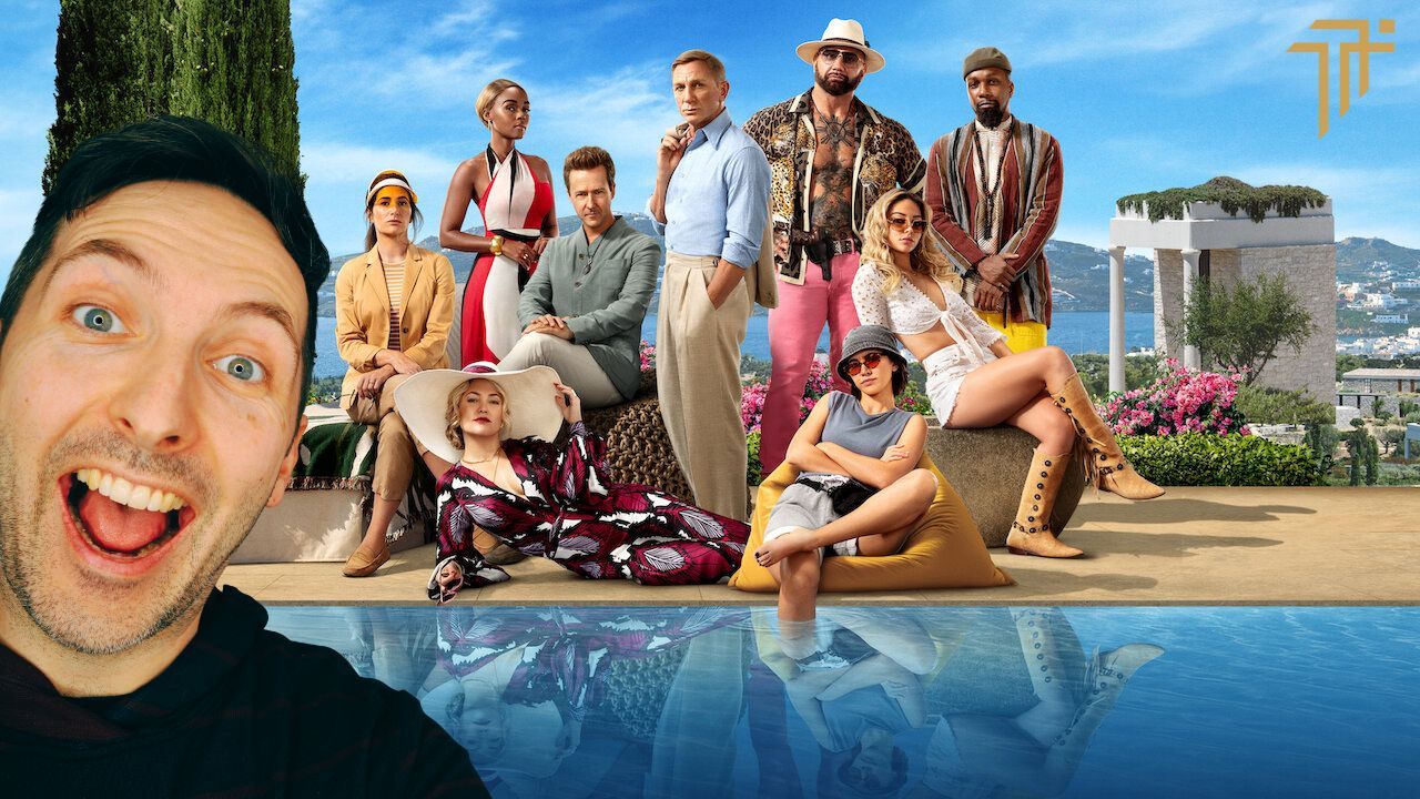 Richard Pryn grinning in front of the Glass Onion cast posing beside a pool