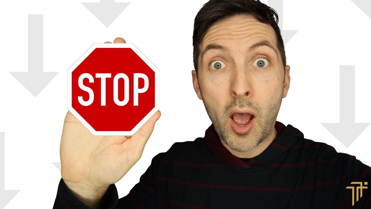 Richard Pryn looking surprised while holding up a red stop sign, with grey downward arrows behind him
