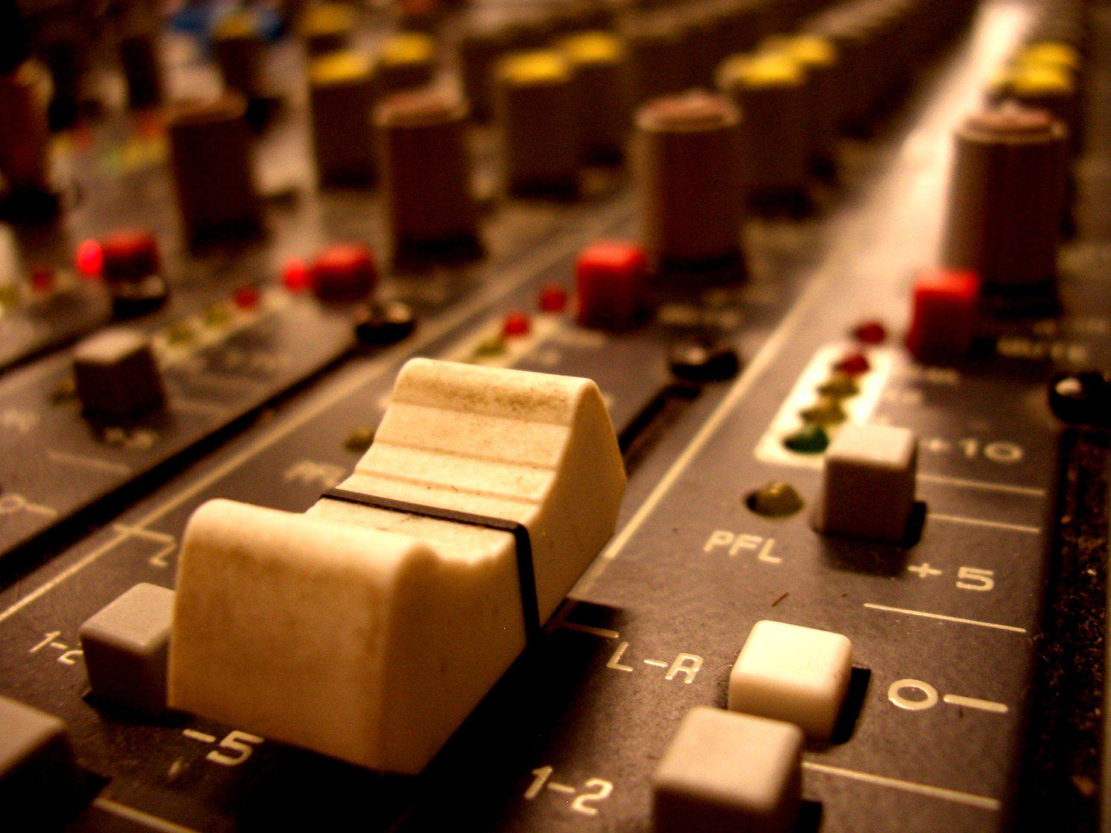 Close-up of a fader and controls on an analogue mixing desk