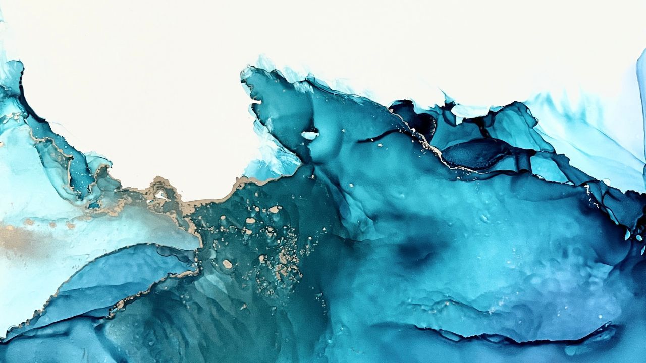 Abstract teal and blue alcohol ink painting with gold flecks on a white background