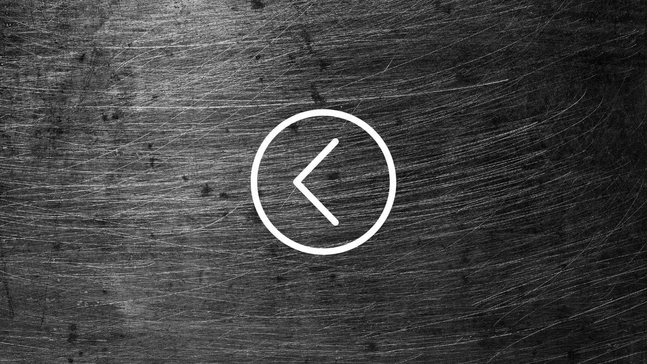White left-pointing arrow in a circle on a scratched dark metal background