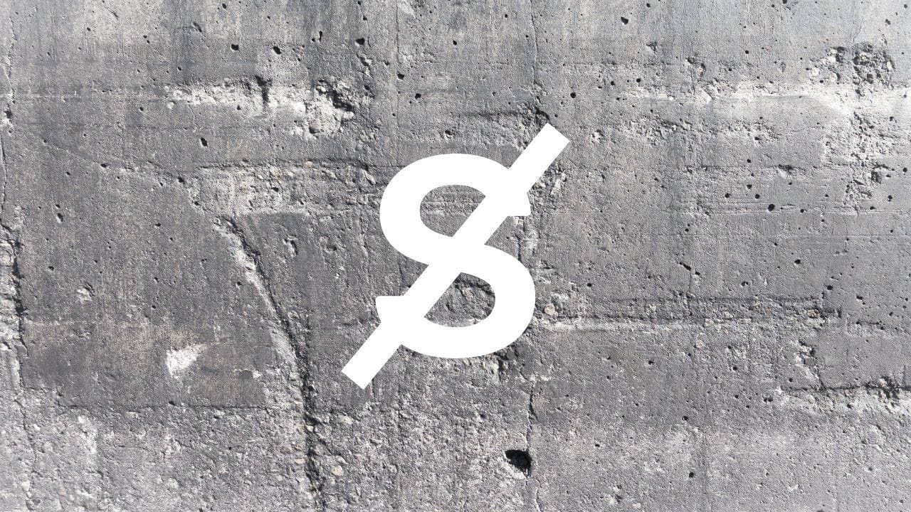 A crossed-out letter S on a grey concrete wall, representing the removal of sibilance