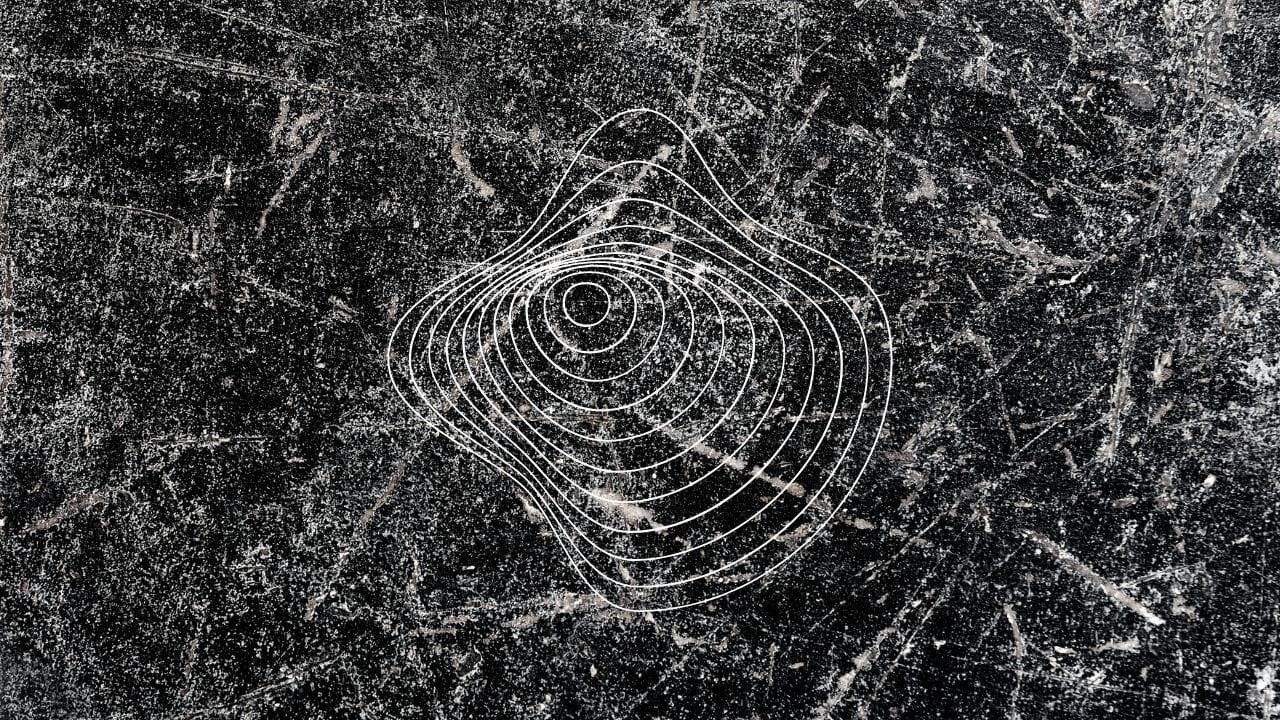 Distorted white concentric rings on a dark scratched background