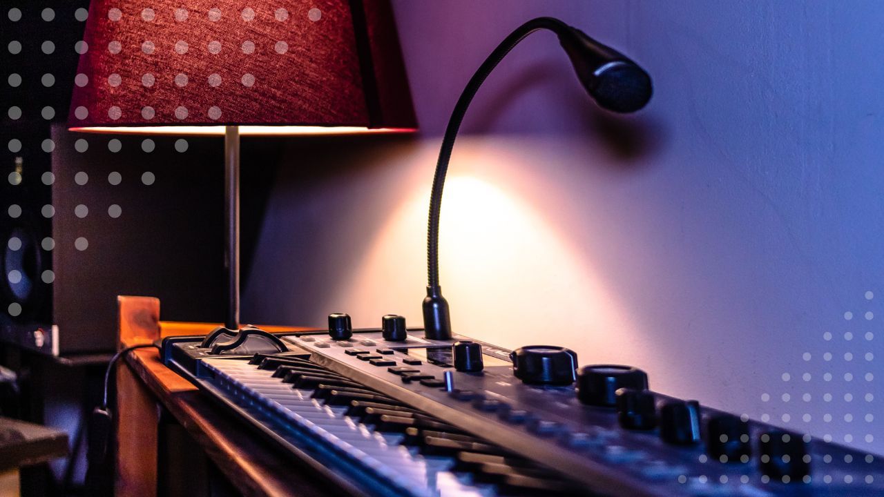 MIDI keyboard with a gooseneck lamp and a red lampshade in a dimly lit studio
