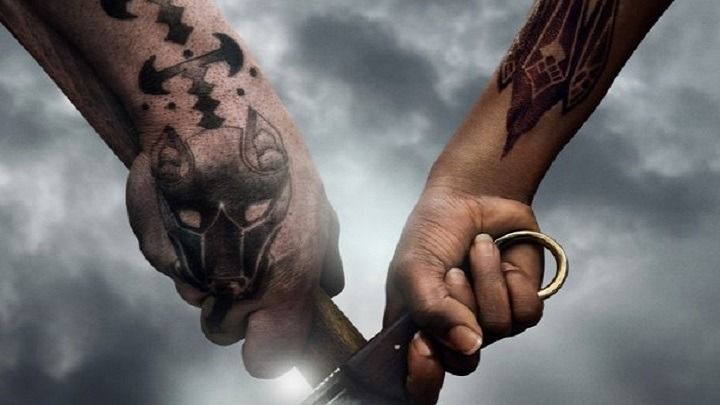 Two tattooed hands gripping a sword hilt against a stormy sky, from The Witcher: Blood Origin