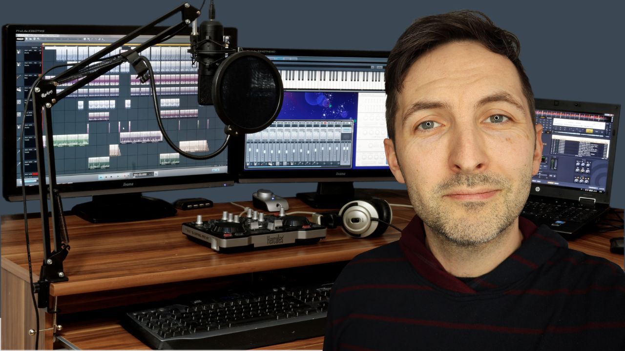 Richard Pryn in front of his home studio desk with monitors, a microphone on a boom arm and headphones