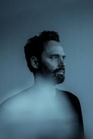 Mood board image: blue-toned portrait of a bearded man gazing to the side