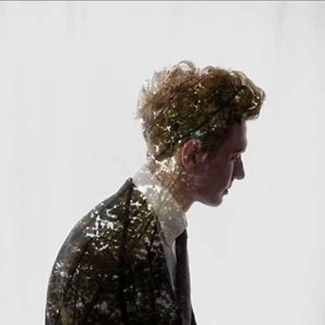 Mood board image: profile of a man in a suit with a double exposure of trees