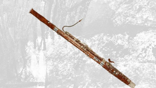A wooden bassoon with its curved metal crook and keys