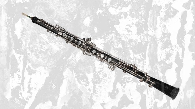 A black oboe with silver keys and a double reed
